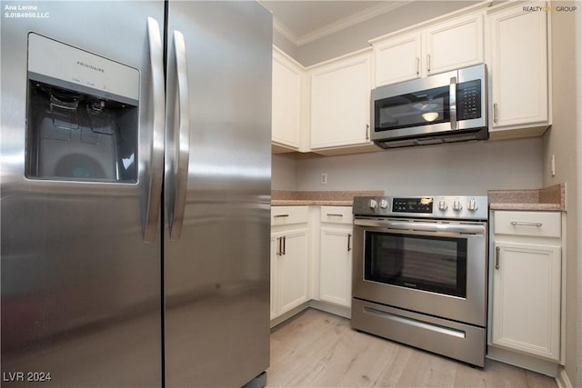 kitchen with white cabinetry, crown molding, light wood-style floors, and stainless steel appliances