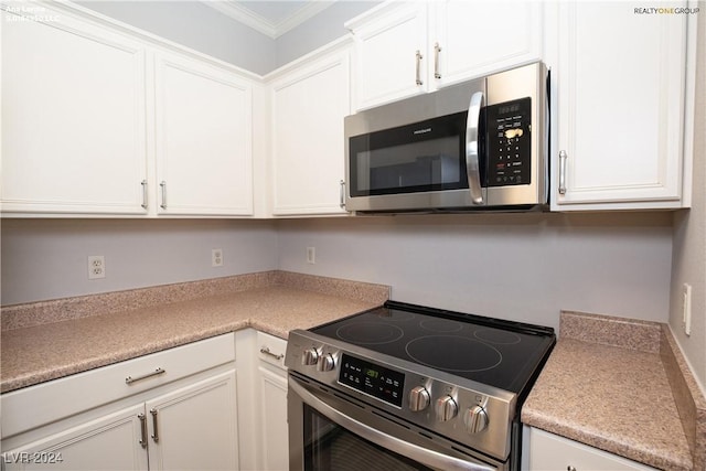 kitchen featuring appliances with stainless steel finishes, white cabinetry, and light countertops