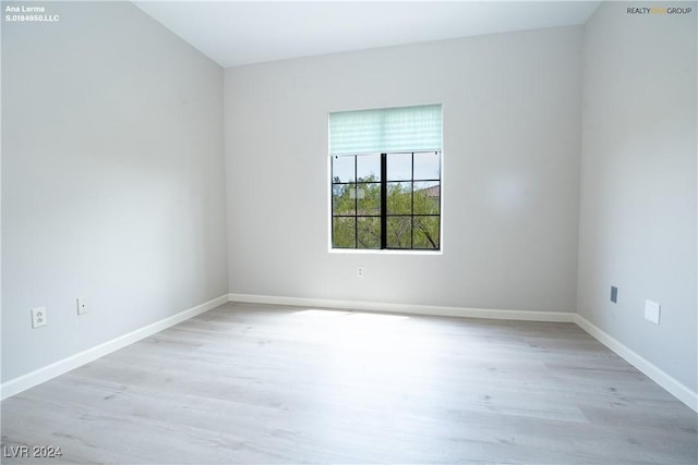 empty room with baseboards and wood finished floors