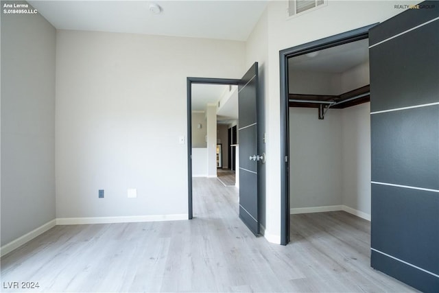 unfurnished bedroom with visible vents, baseboards, and wood finished floors