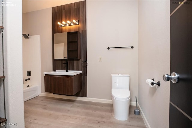 full bathroom featuring toilet, vanity, baseboards, and wood finished floors