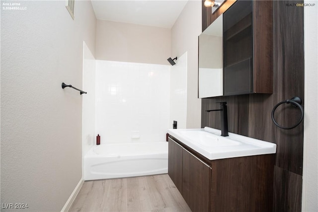 bathroom featuring vanity, bathing tub / shower combination, and wood finished floors