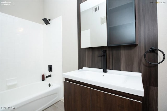 bathroom with vanity, washtub / shower combination, and visible vents