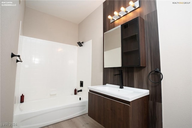 full bathroom with vanity, wood finished floors, and shower / bath combination