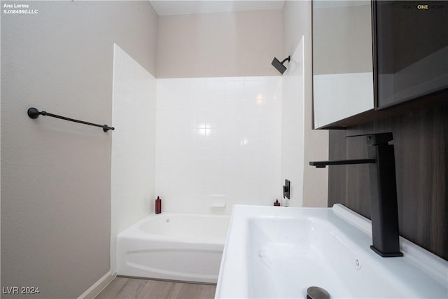 bathroom featuring  shower combination and wood finished floors