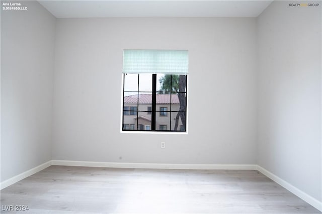 spare room with wood finished floors and baseboards