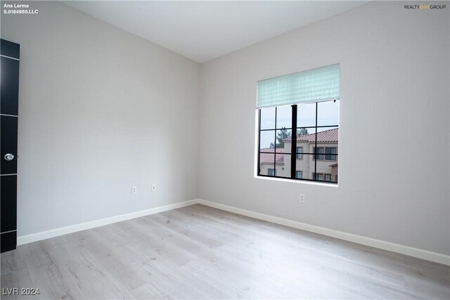 spare room featuring baseboards and wood finished floors