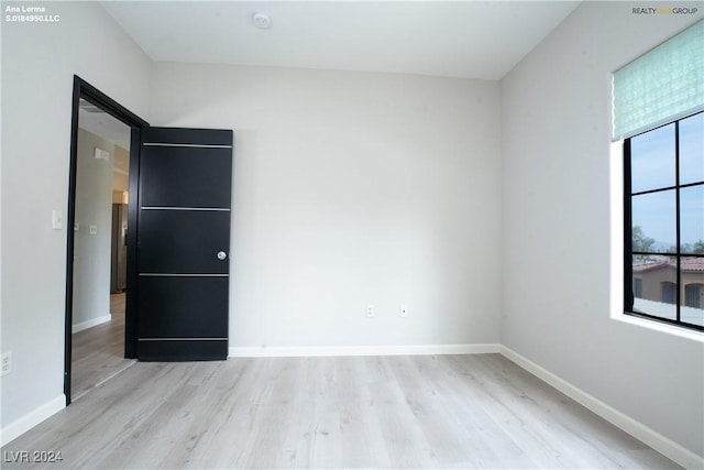 spare room with wood finished floors and baseboards