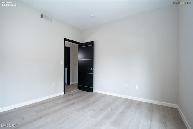 spare room with visible vents, baseboards, and light wood finished floors