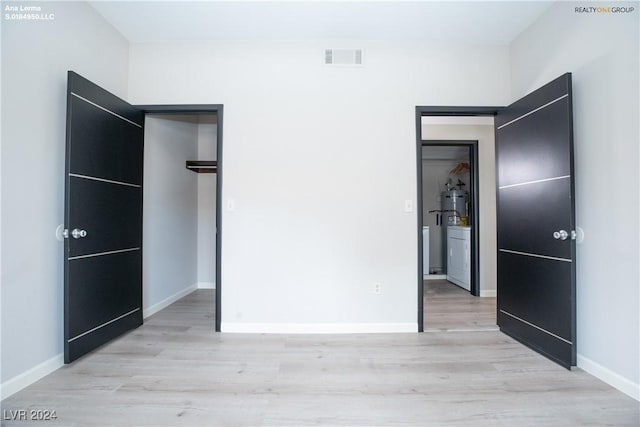 unfurnished bedroom with visible vents, baseboards, and light wood finished floors