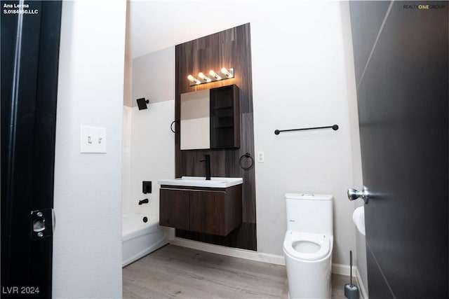 full bath with baseboards, toilet, wood finished floors, and vanity