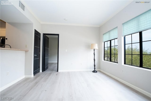 unfurnished room featuring visible vents, crown molding, and baseboards