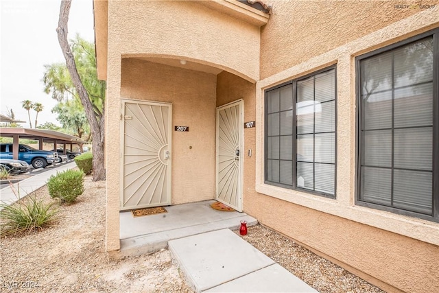 view of exterior entry with stucco siding