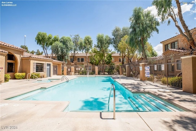 pool with a patio area, a residential view, and fence