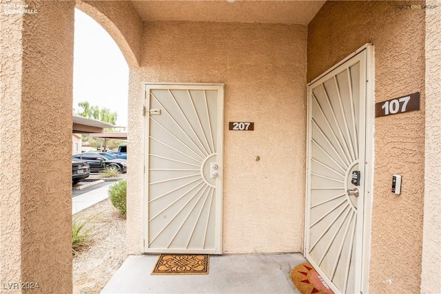 property entrance with stucco siding