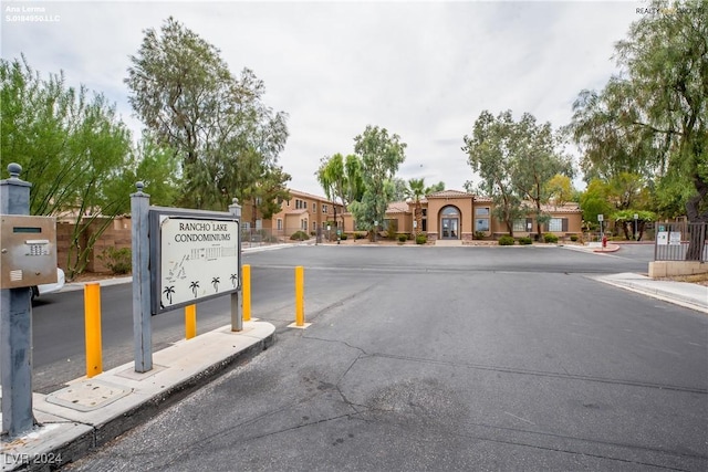 view of street with curbs, sidewalks, and a gated entry