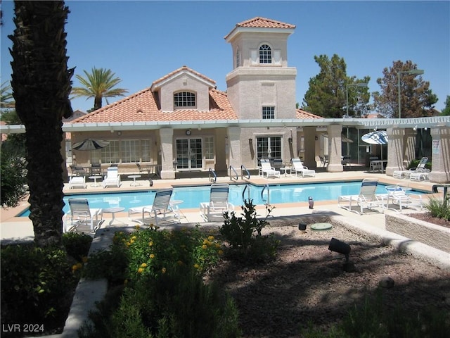 back of house featuring a community pool and a patio