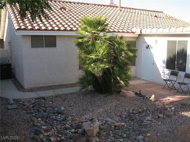 back of house with central AC unit