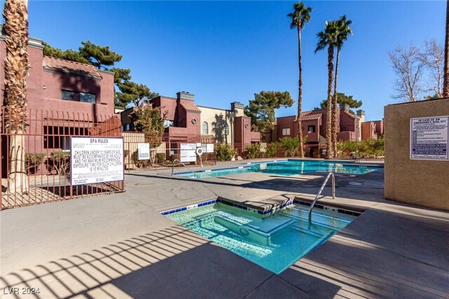 view of pool with a community hot tub and a patio