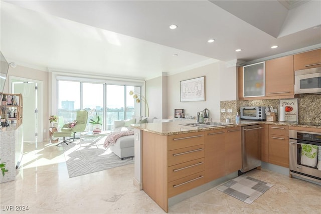 kitchen with light stone counters, sink, oven, and kitchen peninsula