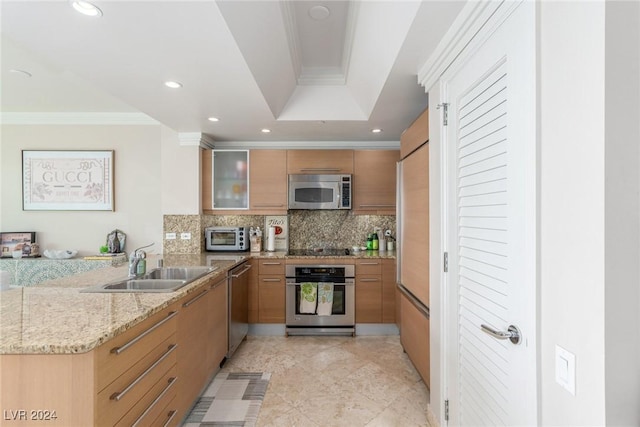 kitchen featuring sink, a tray ceiling, stainless steel appliances, crown molding, and light stone countertops