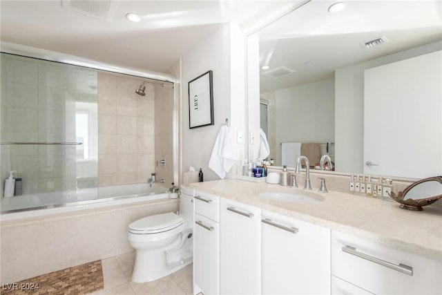 full bathroom featuring toilet, tile patterned floors, vanity, and bath / shower combo with glass door