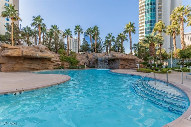 view of swimming pool with pool water feature