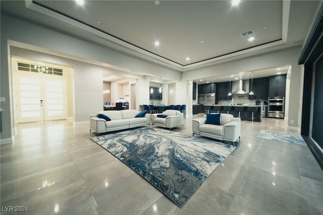 living room featuring a raised ceiling and french doors