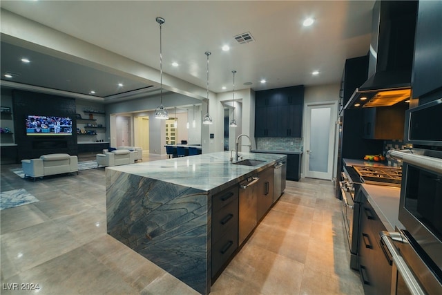 kitchen featuring pendant lighting, sink, a spacious island, extractor fan, and light stone countertops