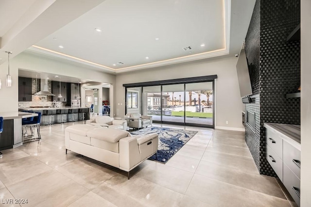 living room with light tile patterned flooring and a tray ceiling