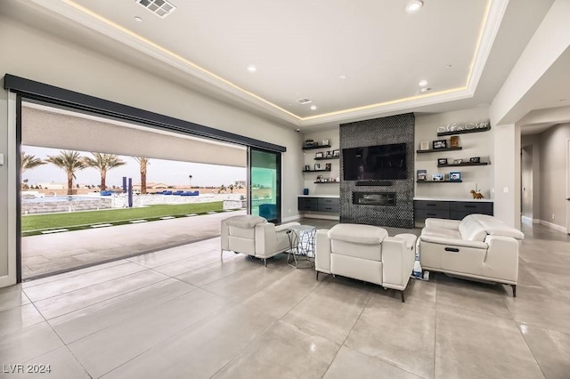 living room with a fireplace and a raised ceiling