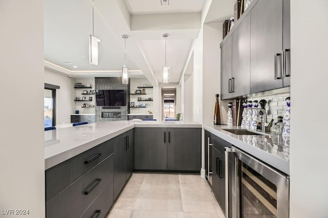 kitchen with tasteful backsplash, sink, decorative light fixtures, and beverage cooler