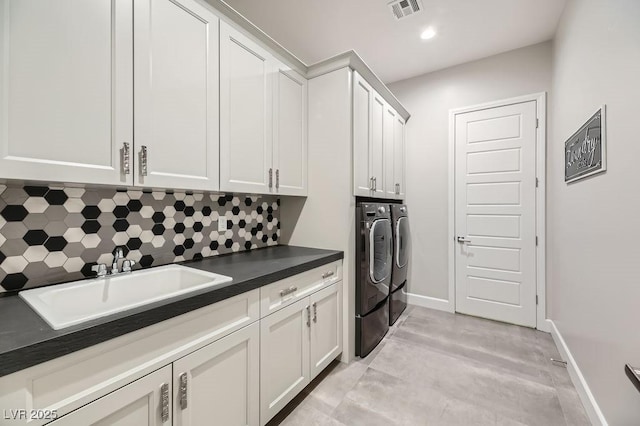 laundry area featuring sink, cabinets, and washer and dryer