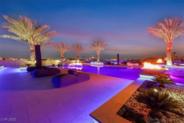 pool at dusk with a patio