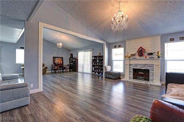 living room with a fireplace, wood-type flooring, a textured ceiling, and a notable chandelier