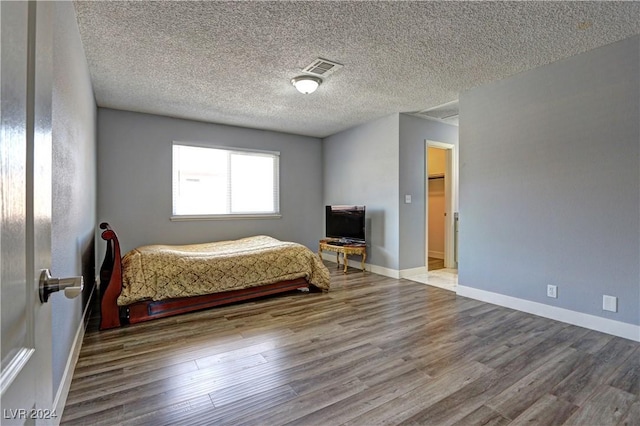 unfurnished bedroom with hardwood / wood-style floors and a textured ceiling