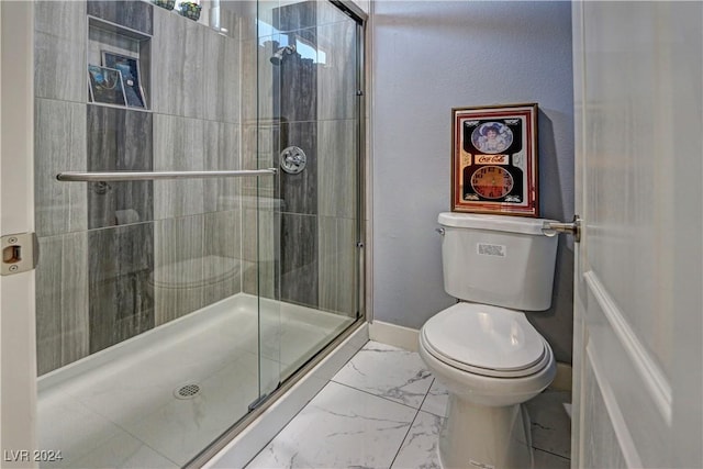 bathroom featuring toilet and a shower with shower door