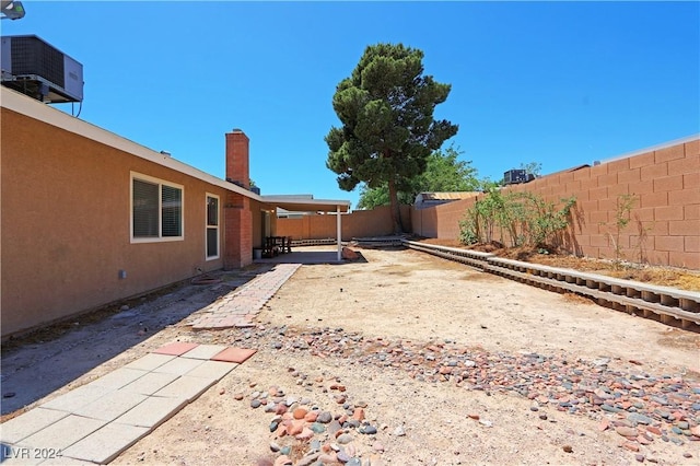 view of yard with central air condition unit and a patio