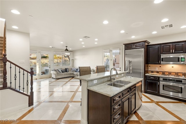 kitchen featuring stainless steel appliances, recessed lighting, a sink, and a kitchen breakfast bar