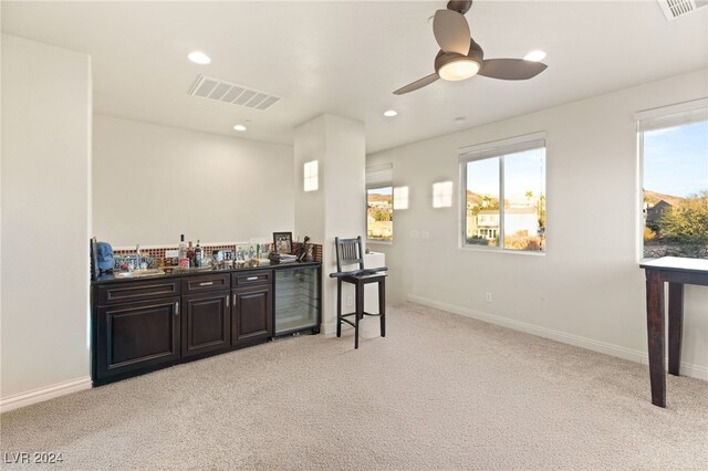 bar with wine cooler, visible vents, wet bar, and light colored carpet