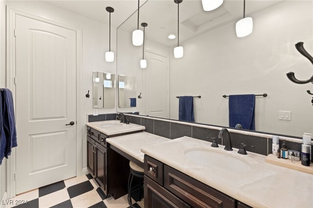 bathroom with double vanity, a sink, and tile patterned floors