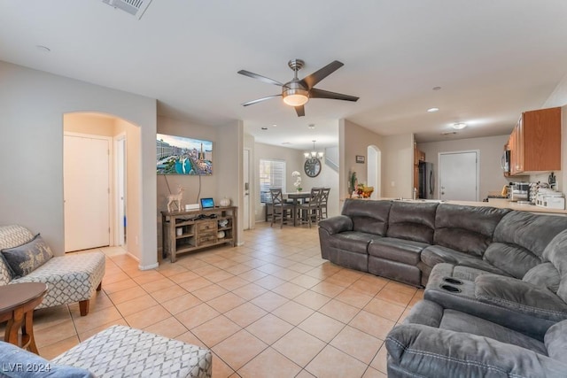 living room with ceiling fan with notable chandelier and light tile patterned flooring