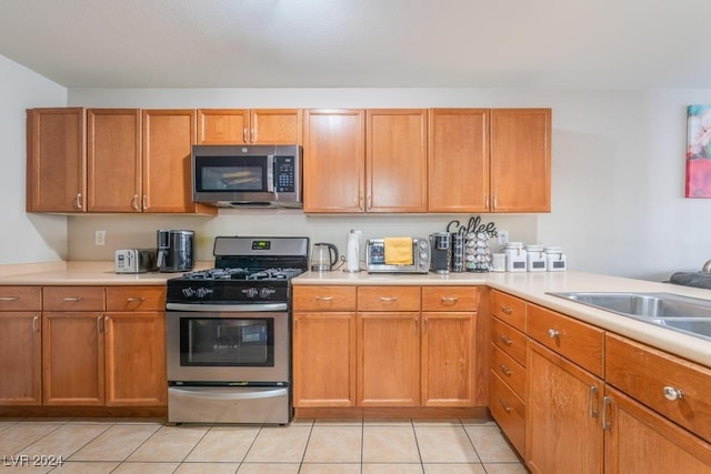 kitchen featuring sink, light tile patterned flooring, and appliances with stainless steel finishes