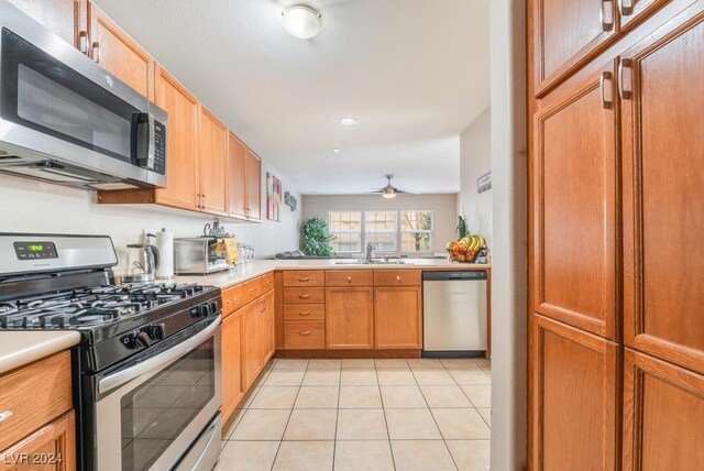 kitchen featuring ceiling fan, appliances with stainless steel finishes, sink, and light tile patterned floors