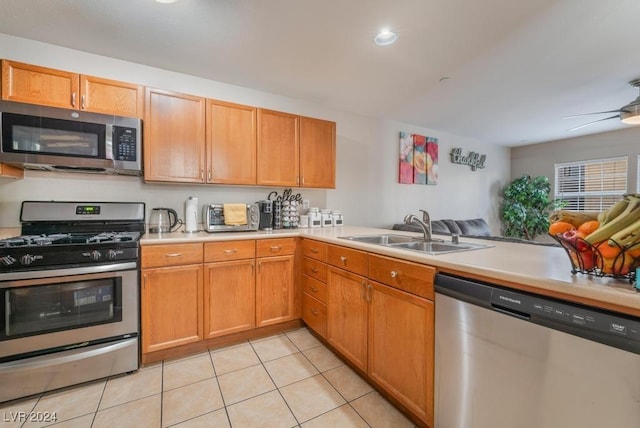 kitchen with sink, ceiling fan, stainless steel appliances, light tile patterned flooring, and kitchen peninsula