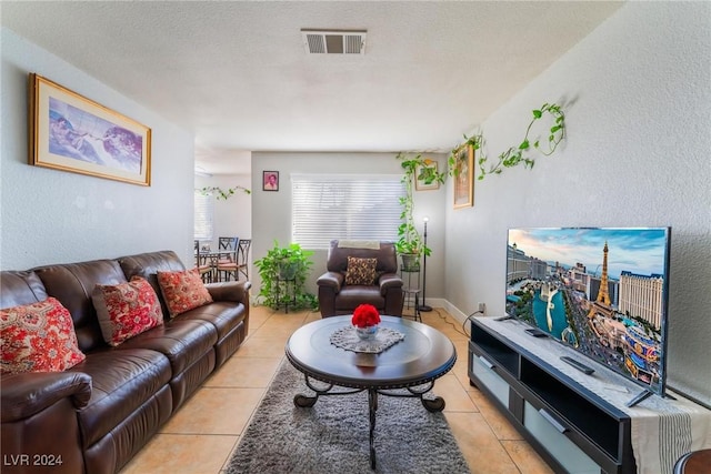 tiled living room featuring a textured ceiling