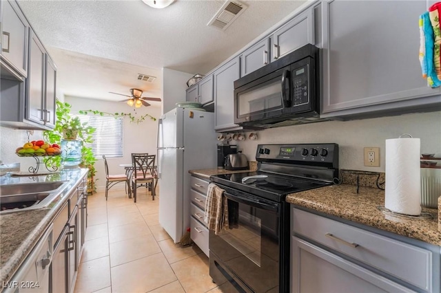 kitchen with gray cabinetry, black appliances, ceiling fan, light tile patterned floors, and a textured ceiling