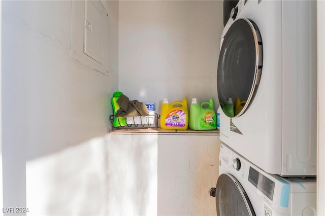 laundry room with electric panel and stacked washer and clothes dryer