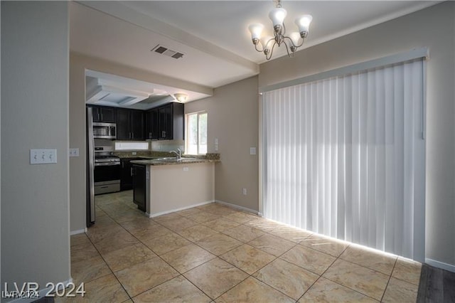 kitchen featuring sink, appliances with stainless steel finishes, beamed ceiling, a notable chandelier, and kitchen peninsula