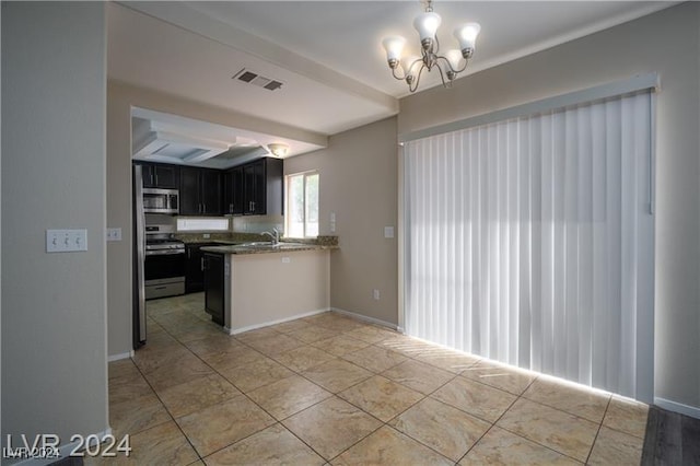 10142 Rice Paper St, Las Vegas, NV 89183 - kitchen with stainless steel appliances, a chandelier, a peninsula, hanging light fixtures, and light tile patterned floors